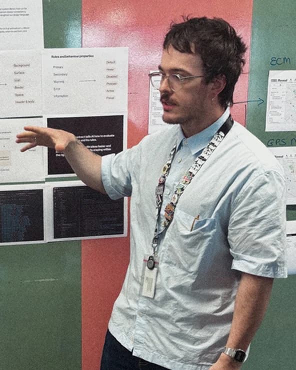 Gabriel Pauli walking through design system work pinned to a wall